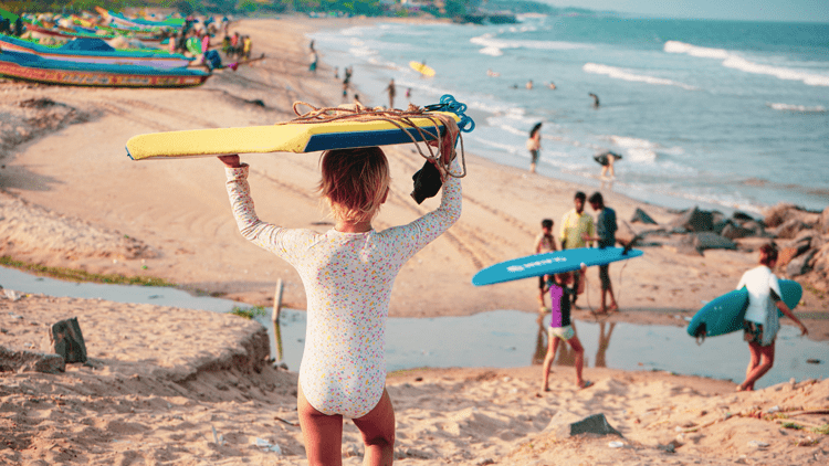 Kid carrying a surfboards