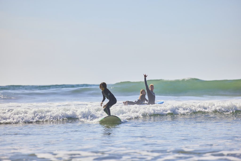 Family catching oceanside waves