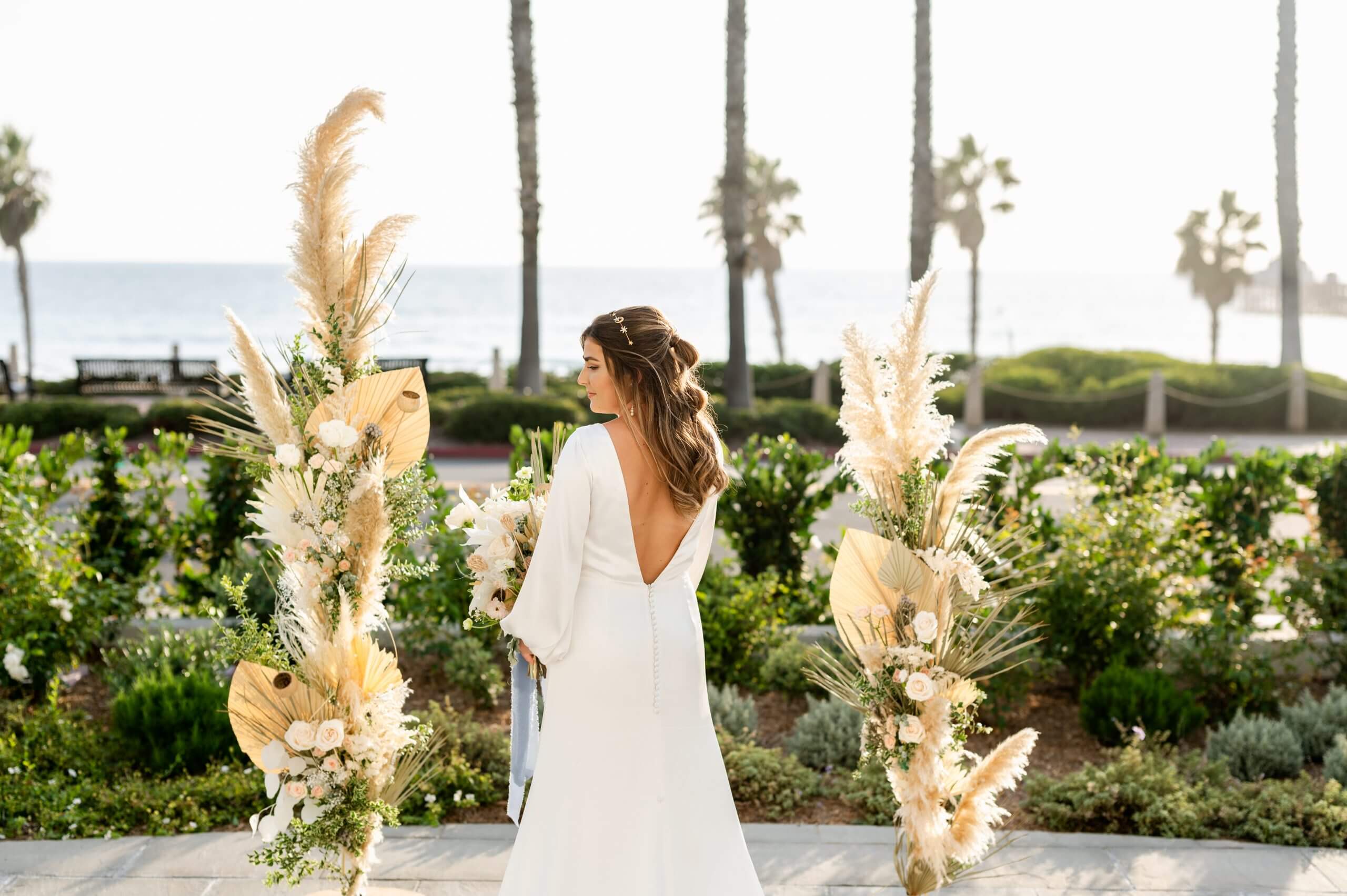 The bride holding a white bouquet with the sea as a backdrop