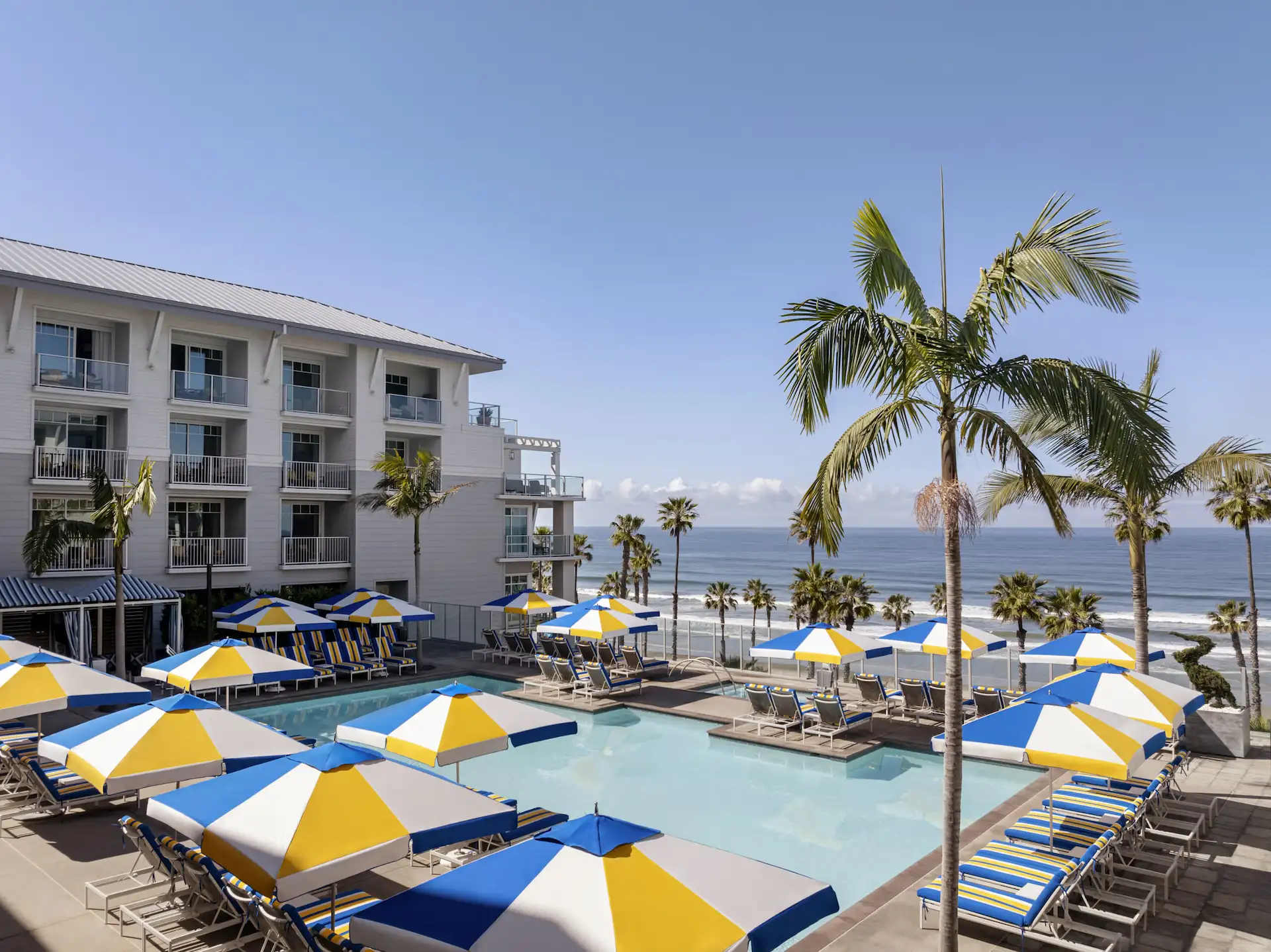 Pool with umbrellas and chairs, overlooking ocean