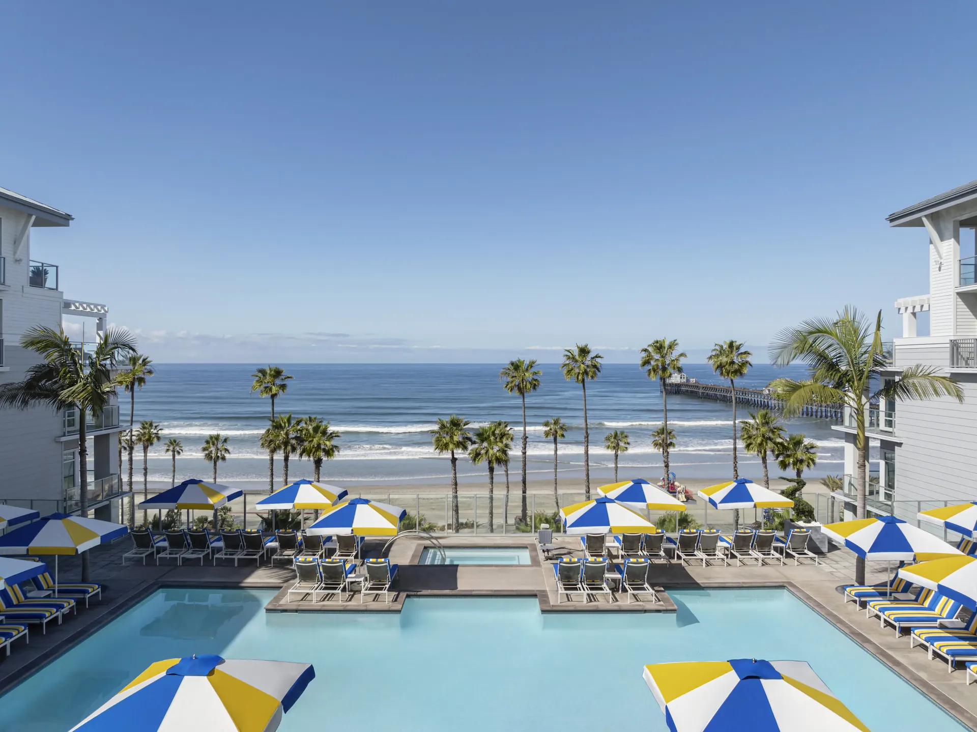 Pool with umbrellas and chairs, overlooking ocean